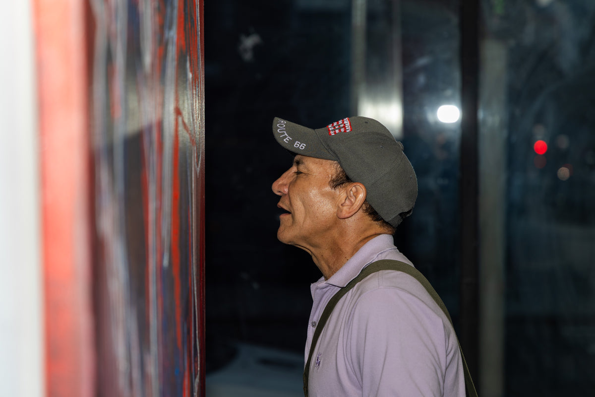 A visitor looks up at one of Kelly O'Brien's paintings